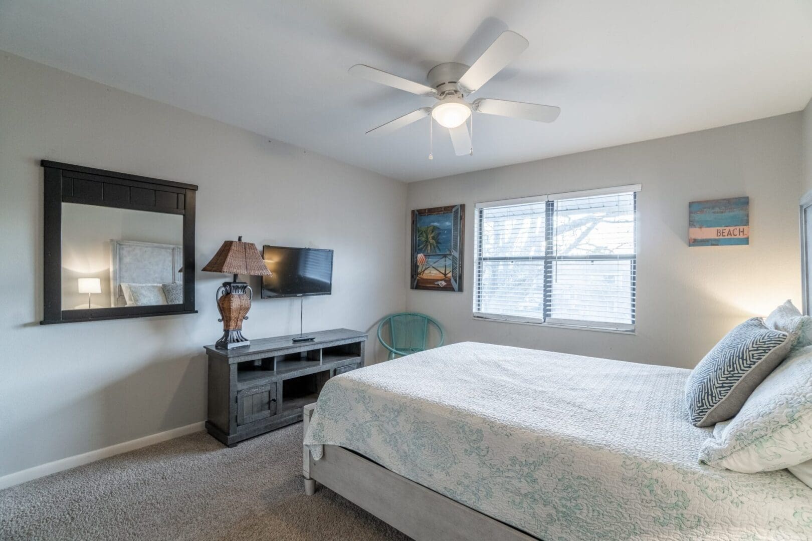 A bedroom with a bed, tv and dresser.