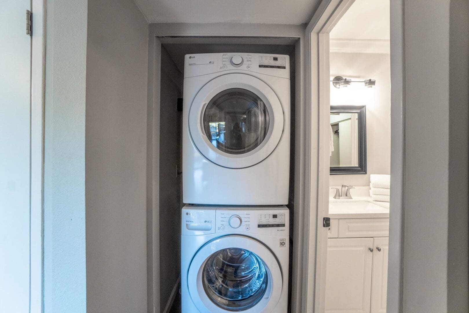 A white washer and dryer in the corner of a room.