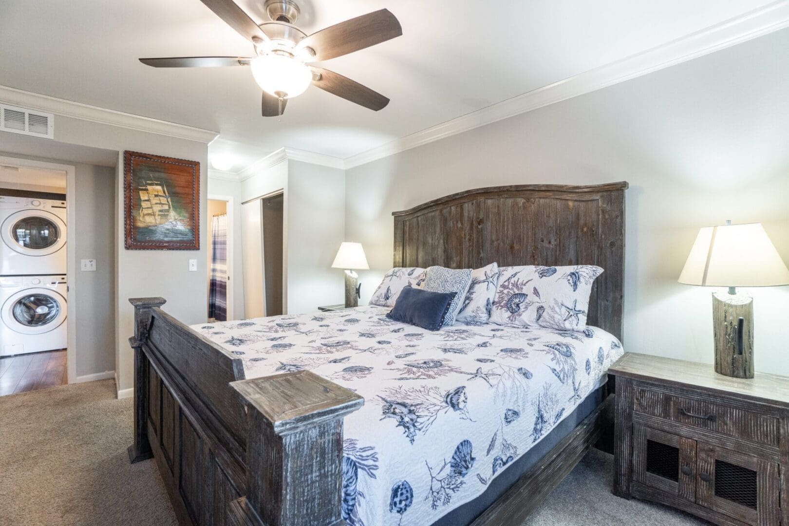 A bedroom with a bed, nightstand and ceiling fan.