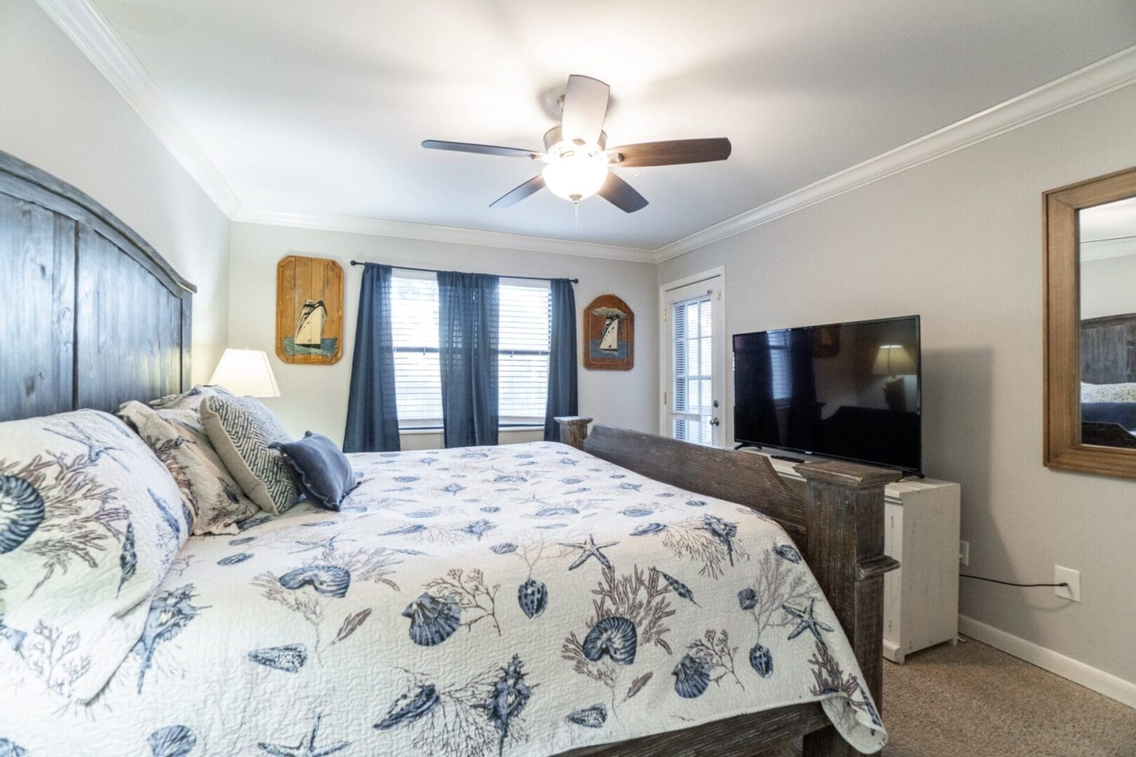 A bedroom with a bed, dresser and tv.