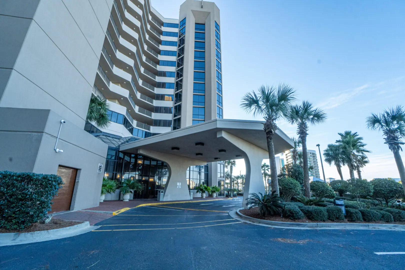 A large building with palm trees in front of it.