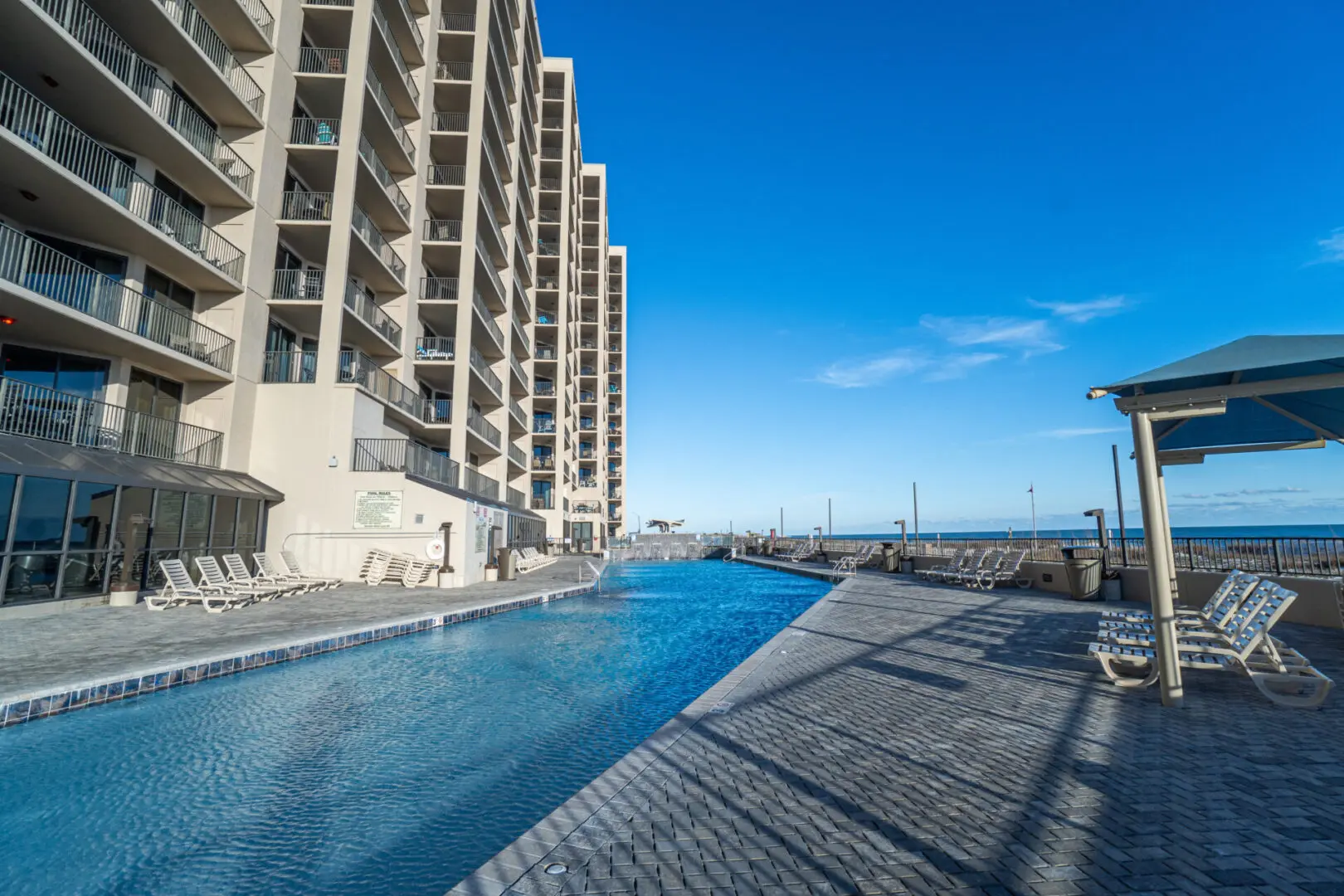 A pool with a view of the ocean and buildings.