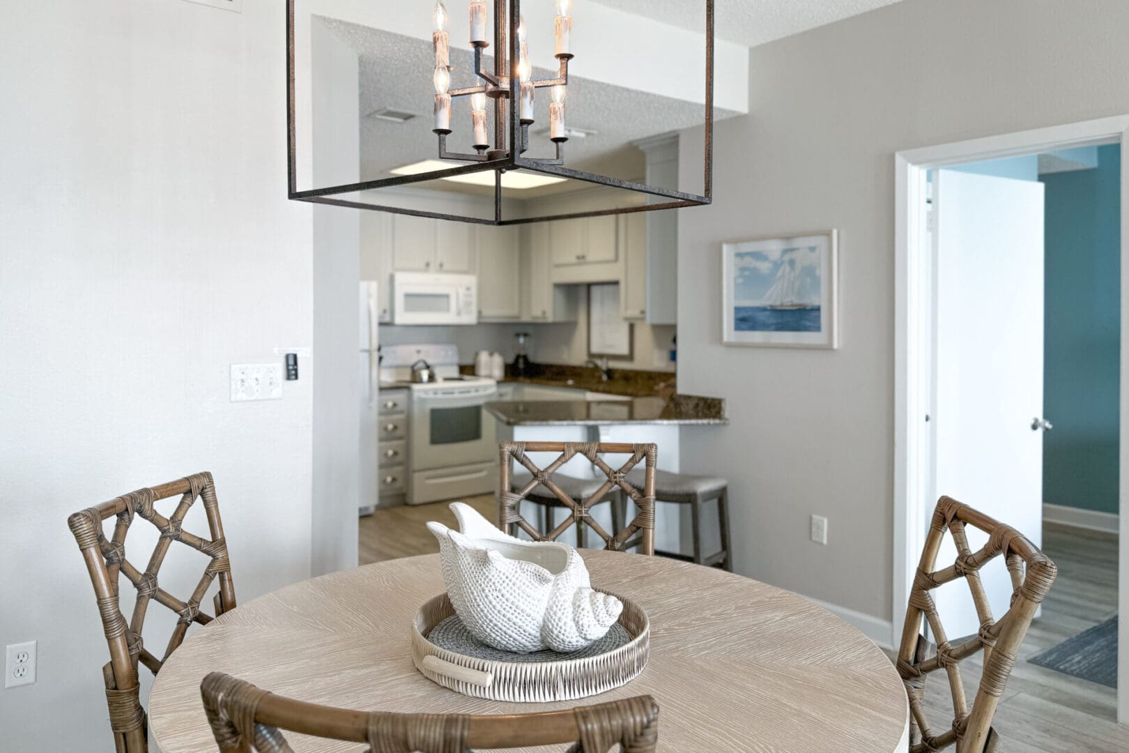 A dining room table with chairs and a chandelier.