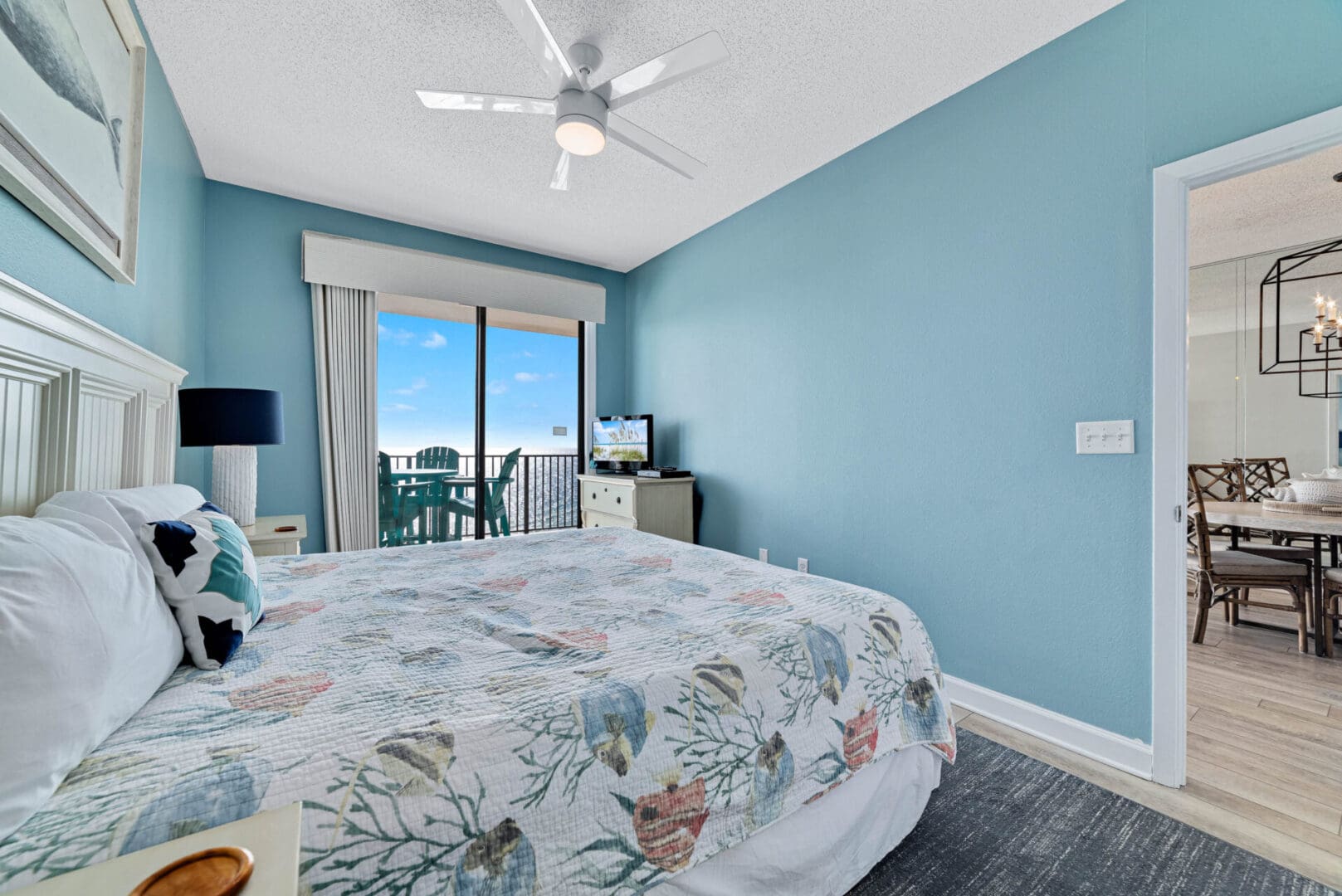 A bedroom with a bed, tv and balcony.