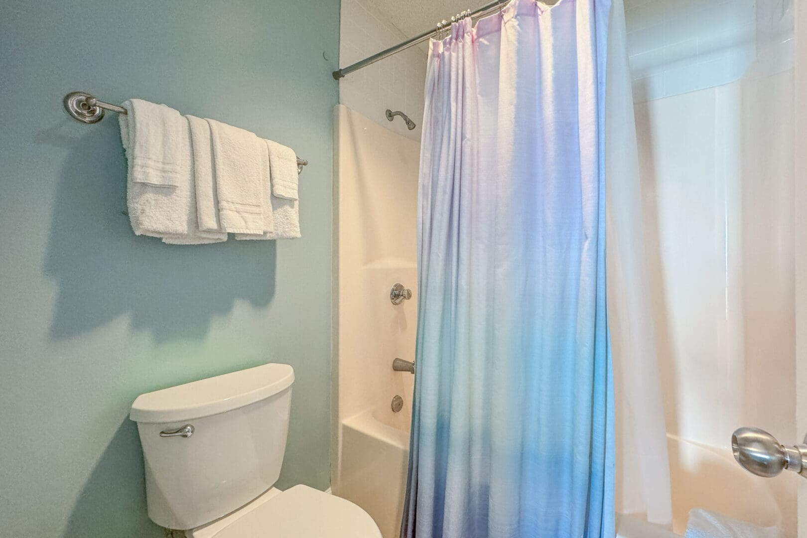 A bathroom with blue walls and white fixtures.