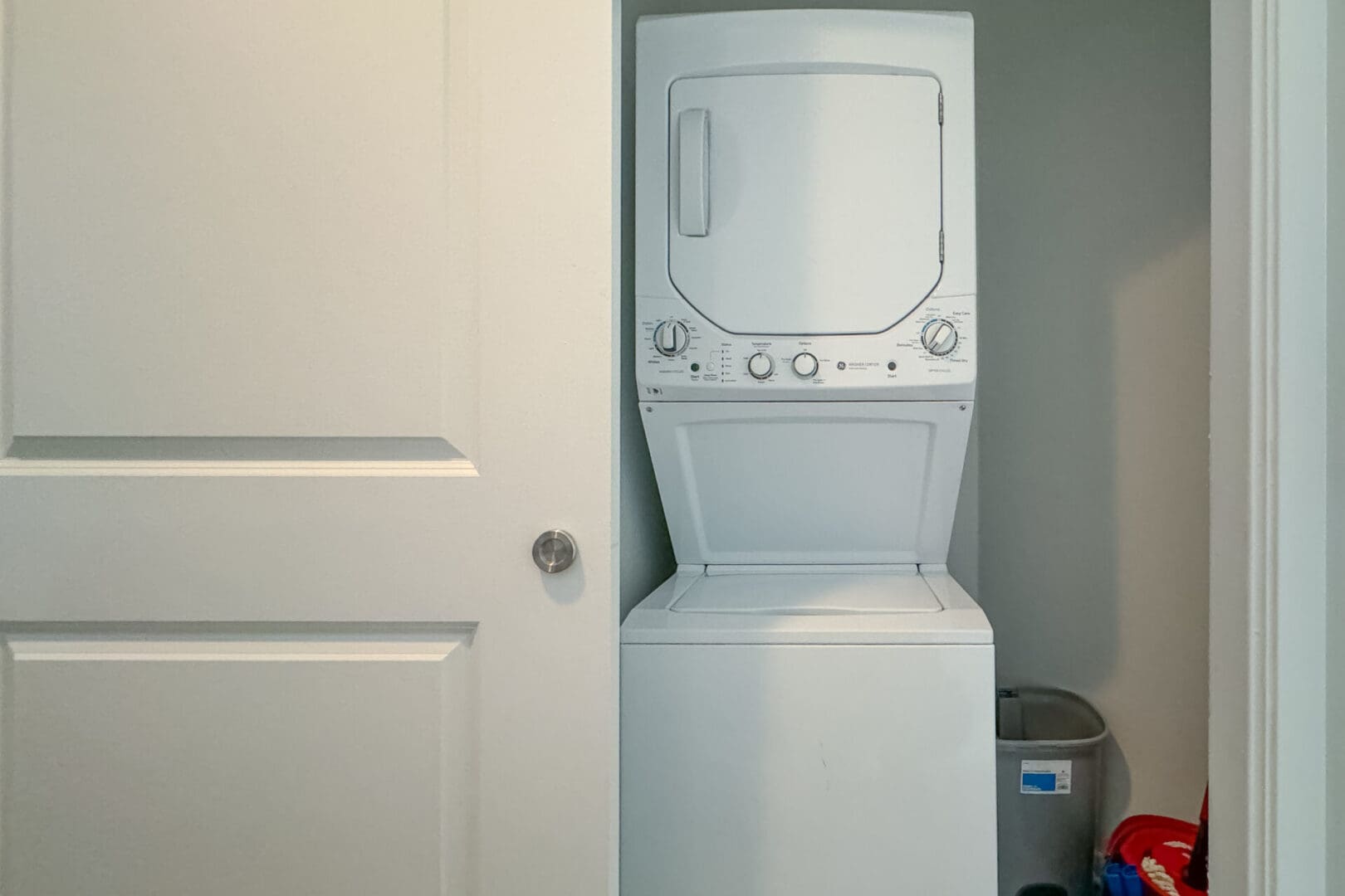 A white washer and dryer in the corner of a room.