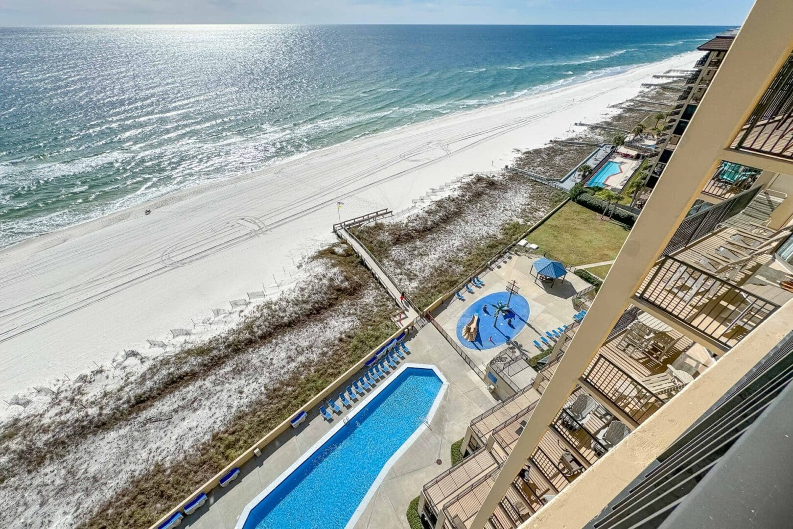 A view of the beach from above shows a pool, and a sandy shoreline.