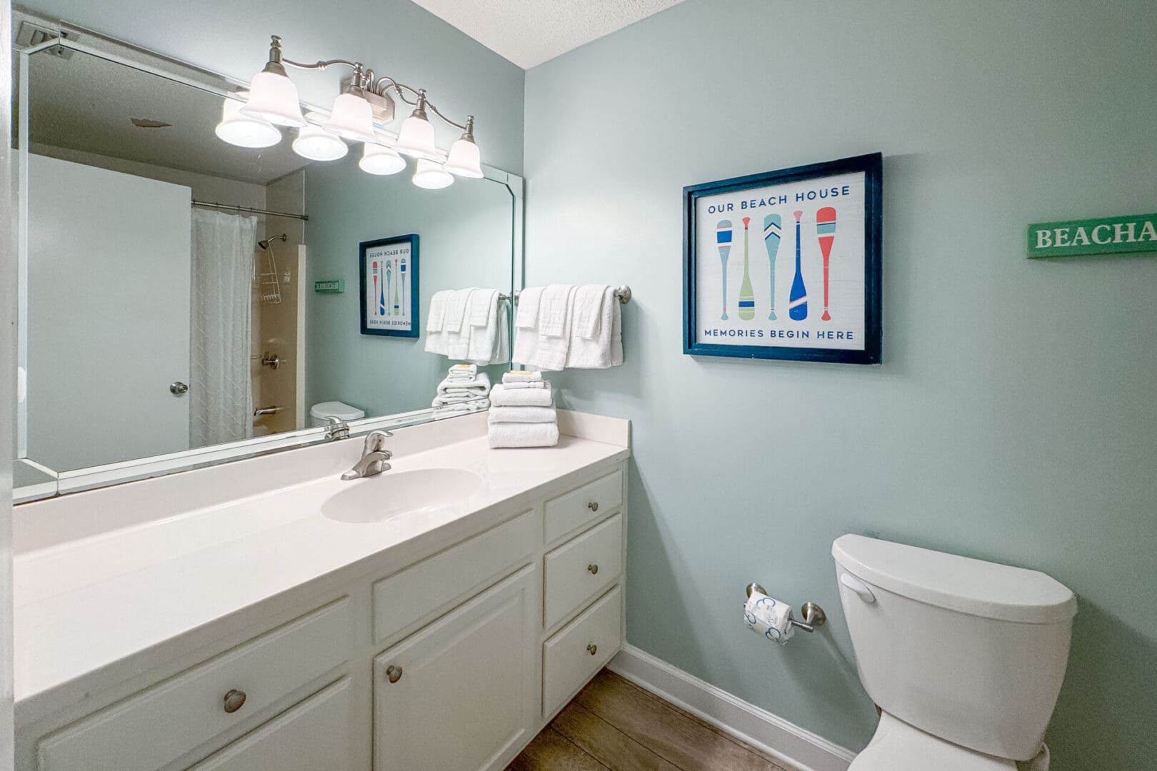 A bathroom with a sink, mirror and toilet.