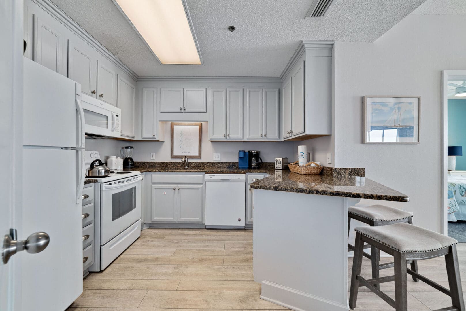 A kitchen with white cabinets and tile floors.