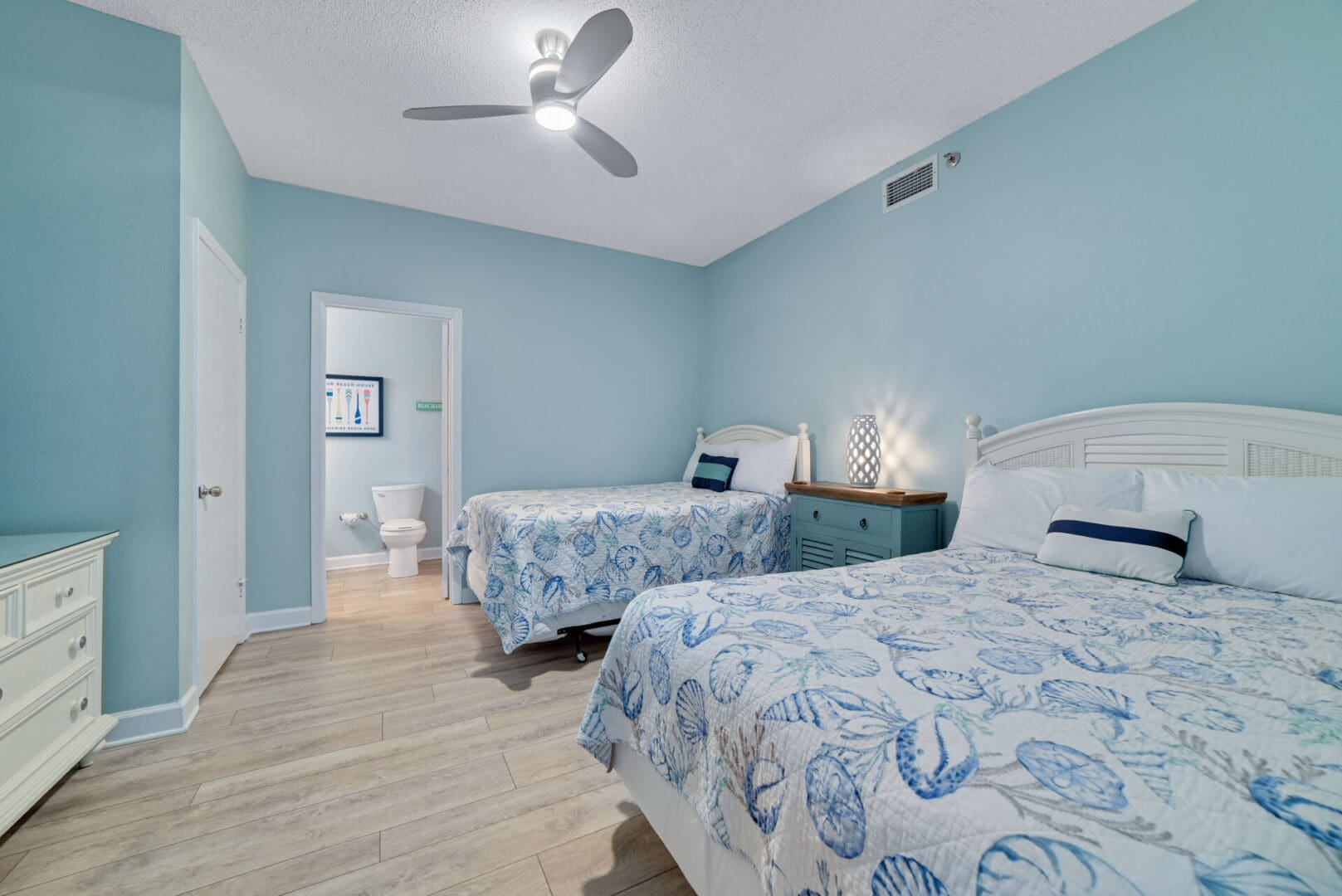 A bedroom with two beds and blue walls.