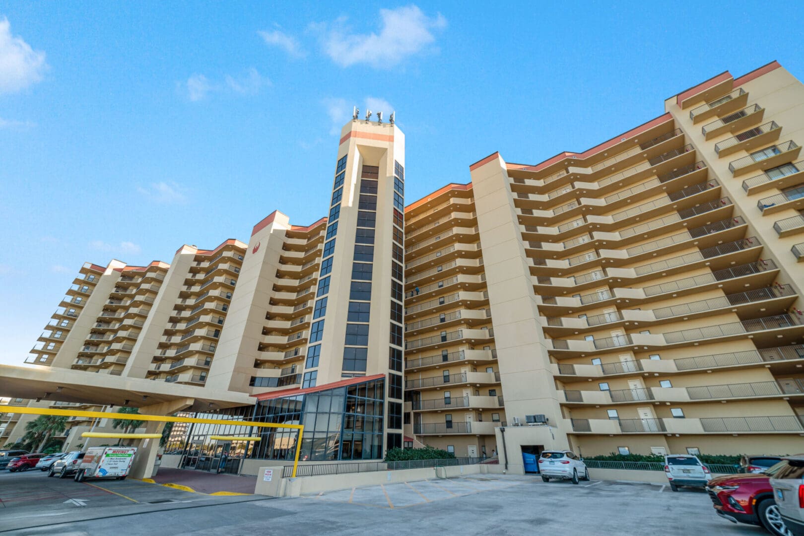 A tall building with many windows and a car parked in front of it.