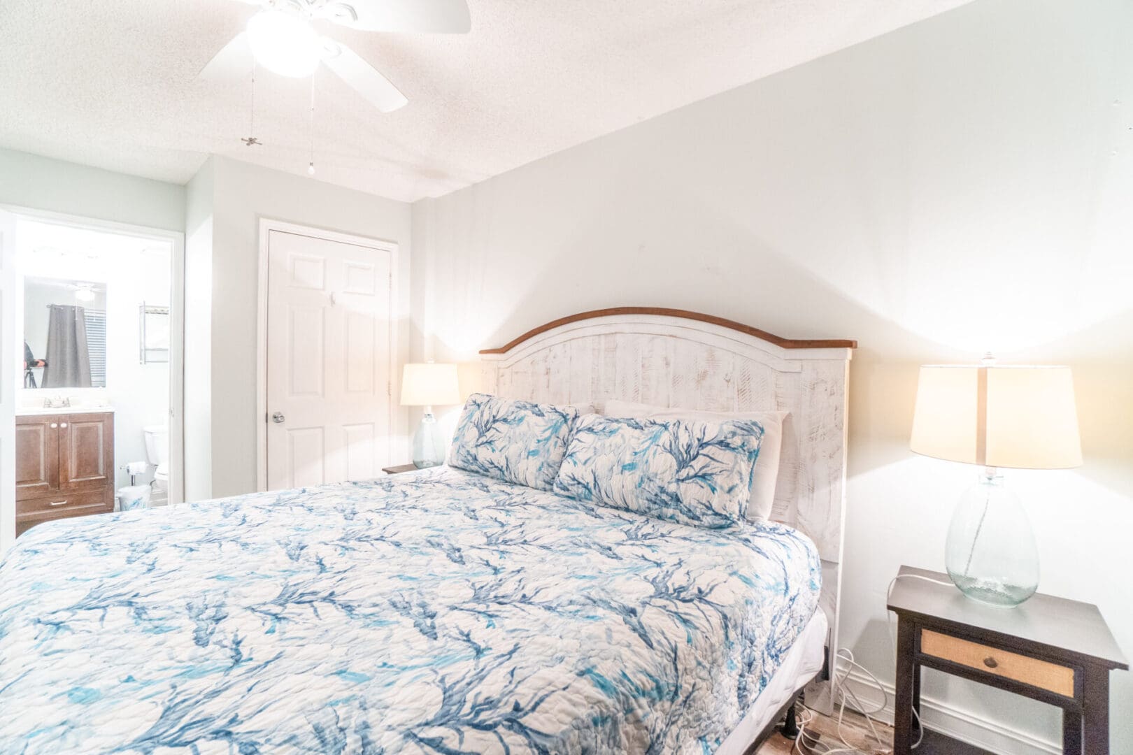 A bed room with a blue and white floral bedspread