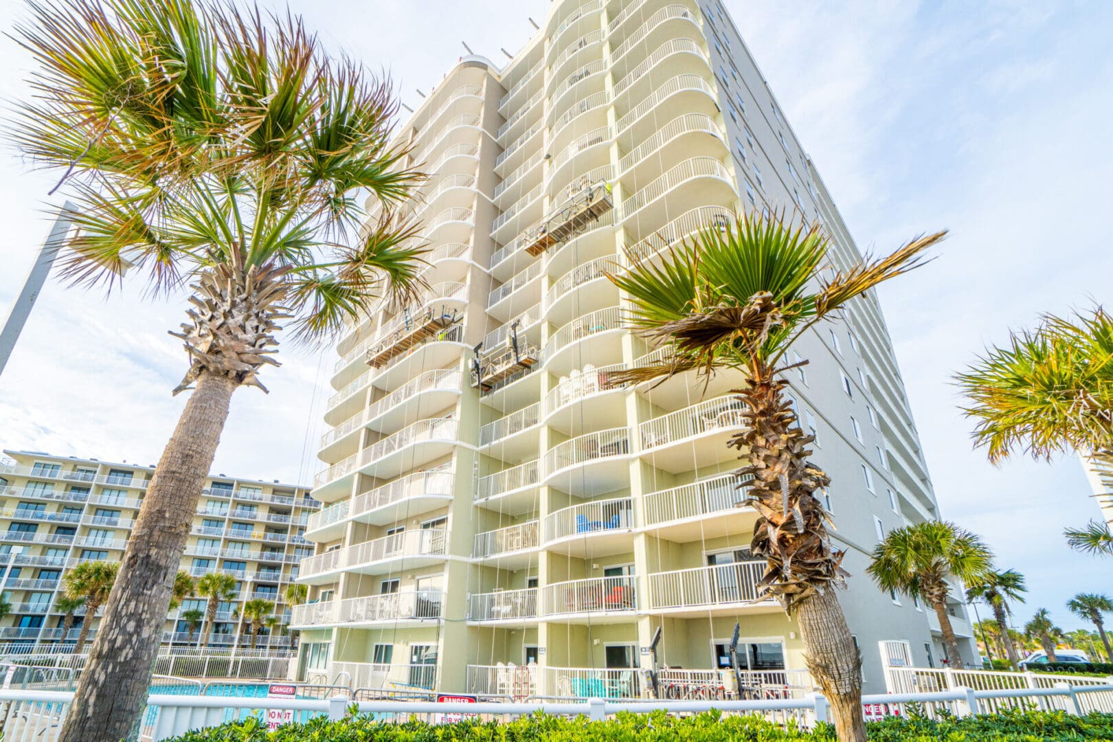 A large building with palm trees in front of it.