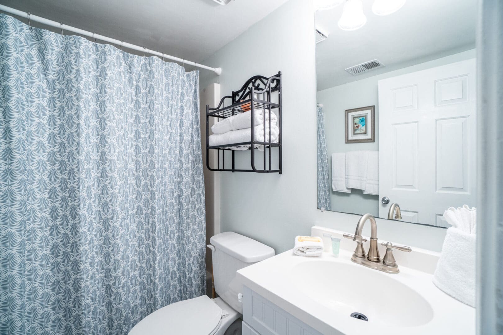 A bathroom with a toilet, sink and mirror.