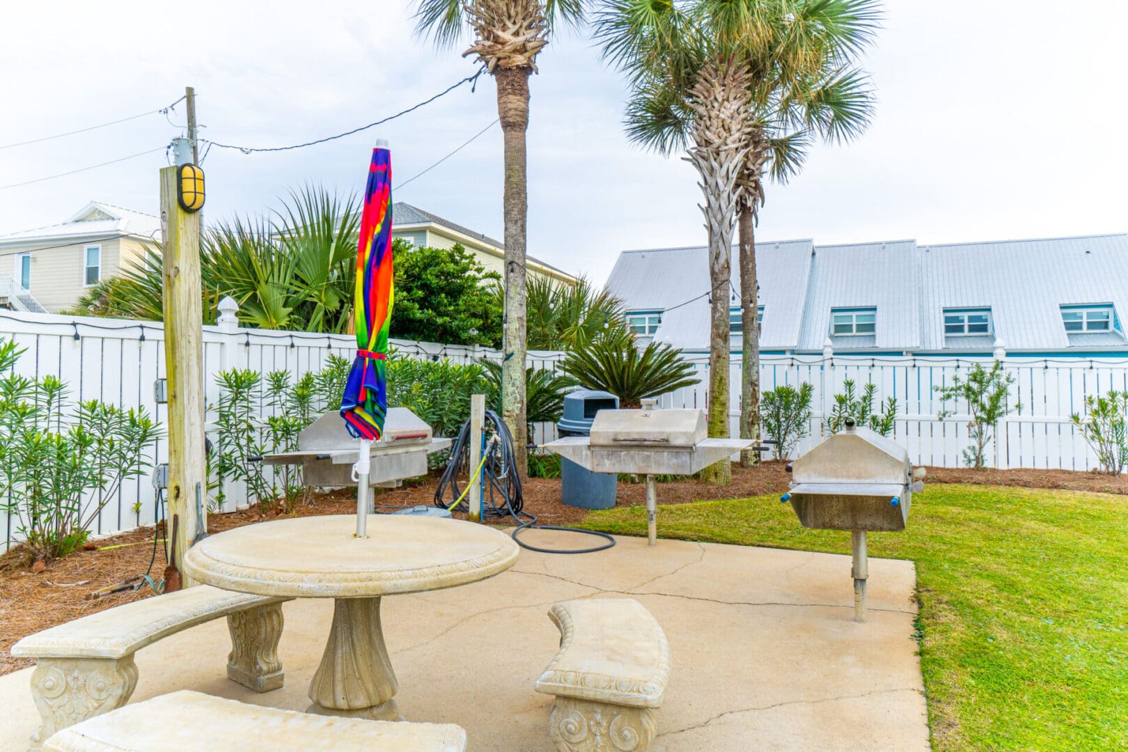 A patio with tables and benches in the back yard.