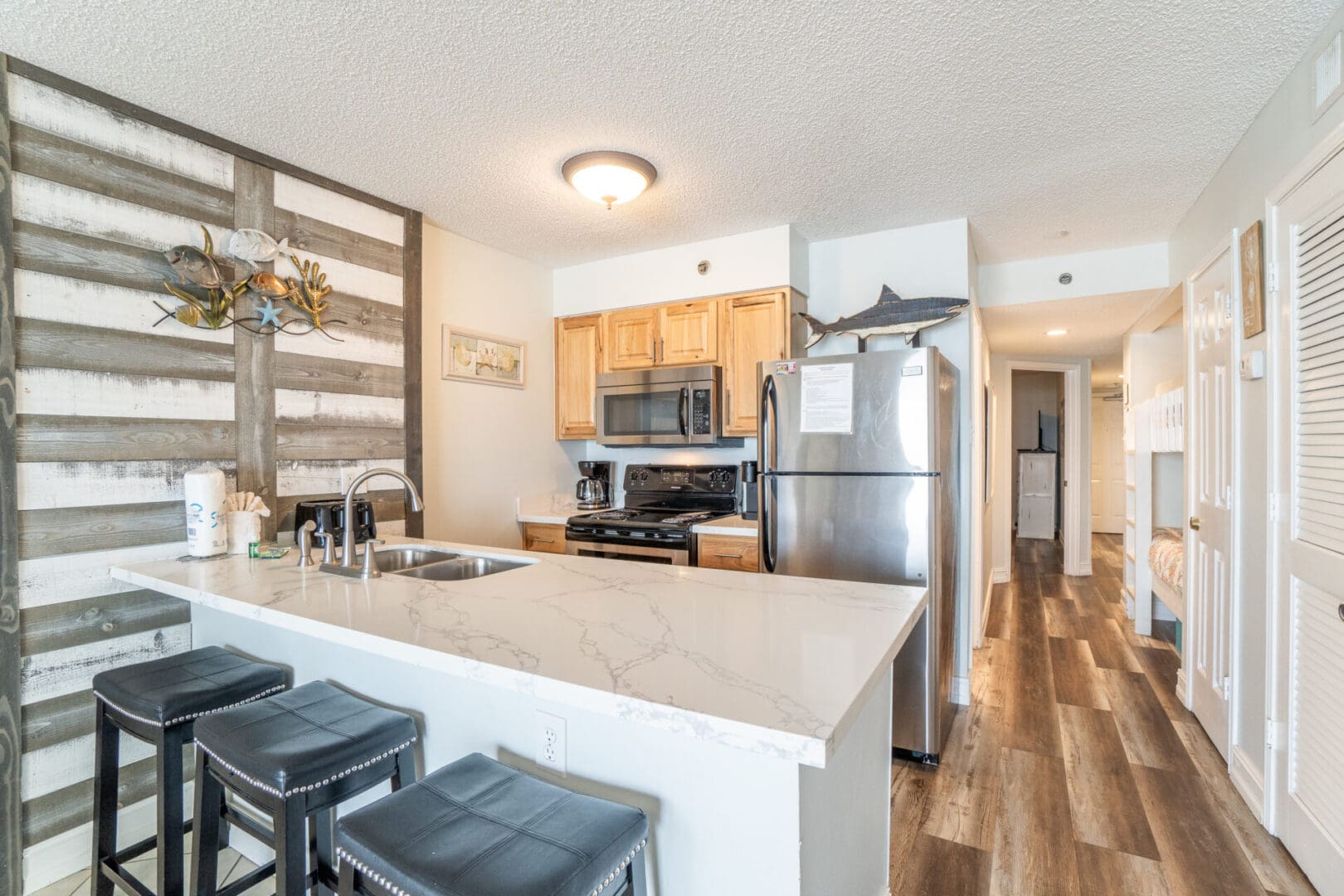 A kitchen with stainless steel appliances and wooden floors.