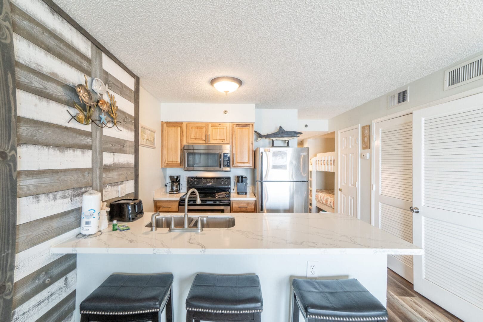 A kitchen with a sink, stove and refrigerator.