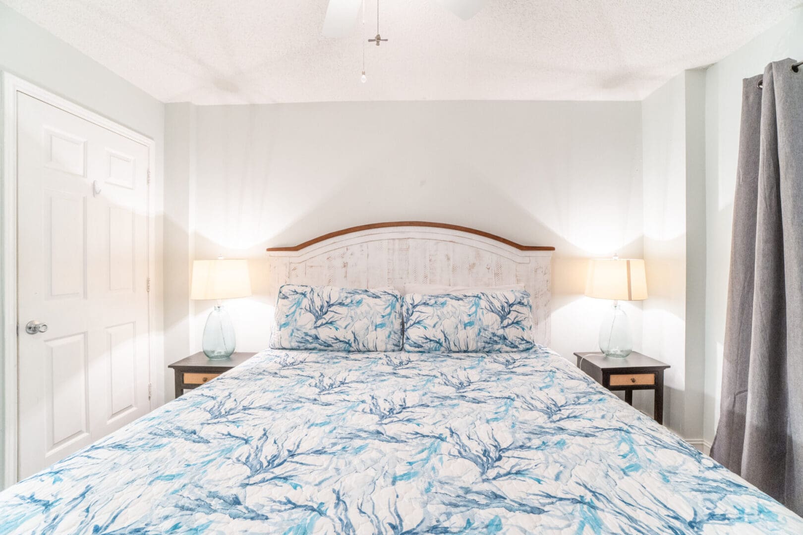 A bed with blue and white floral sheets