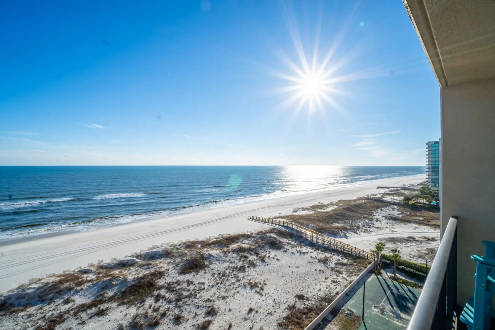 A beach with the sun shining over it.