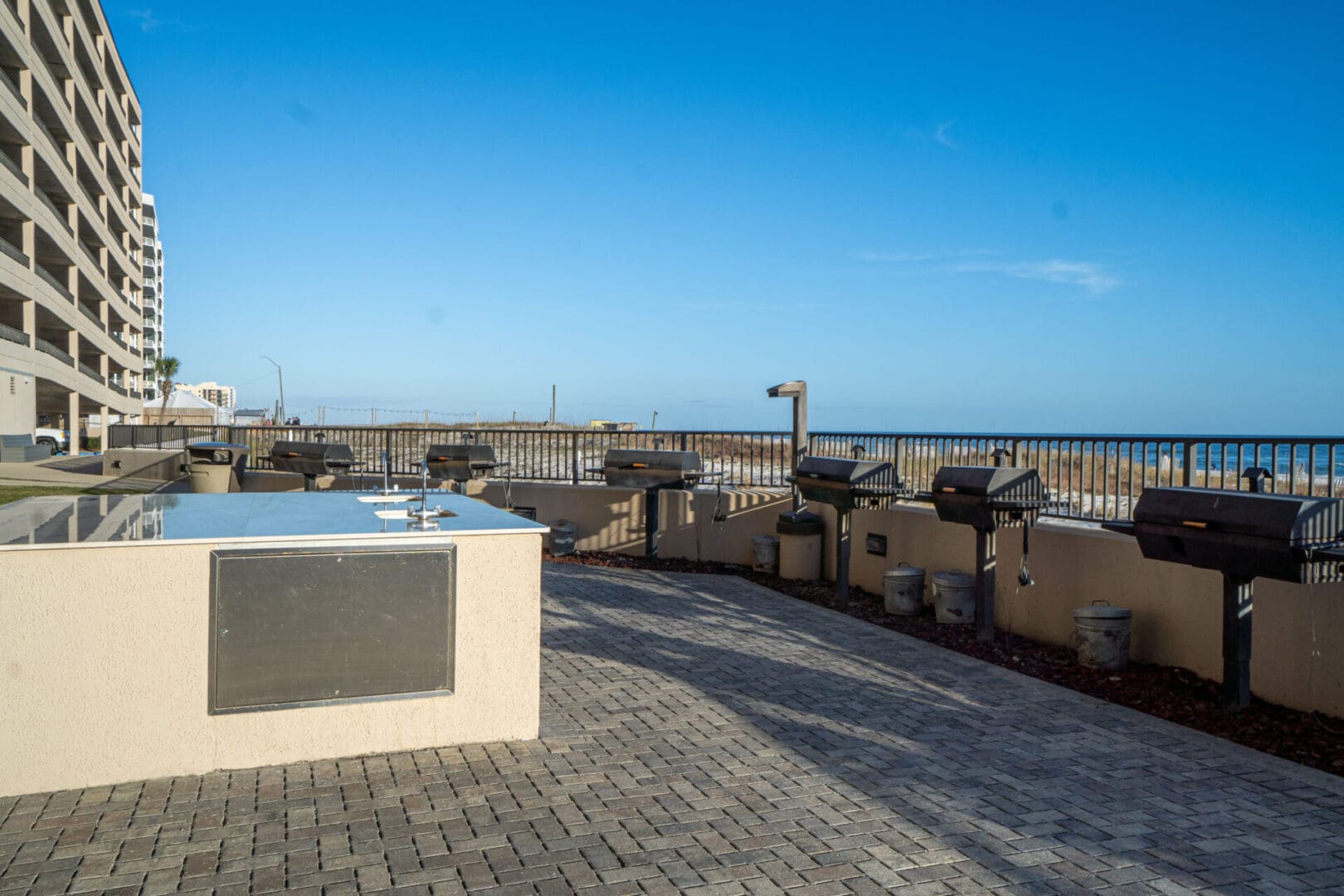 A grill and hot tub on the patio of an apartment complex.