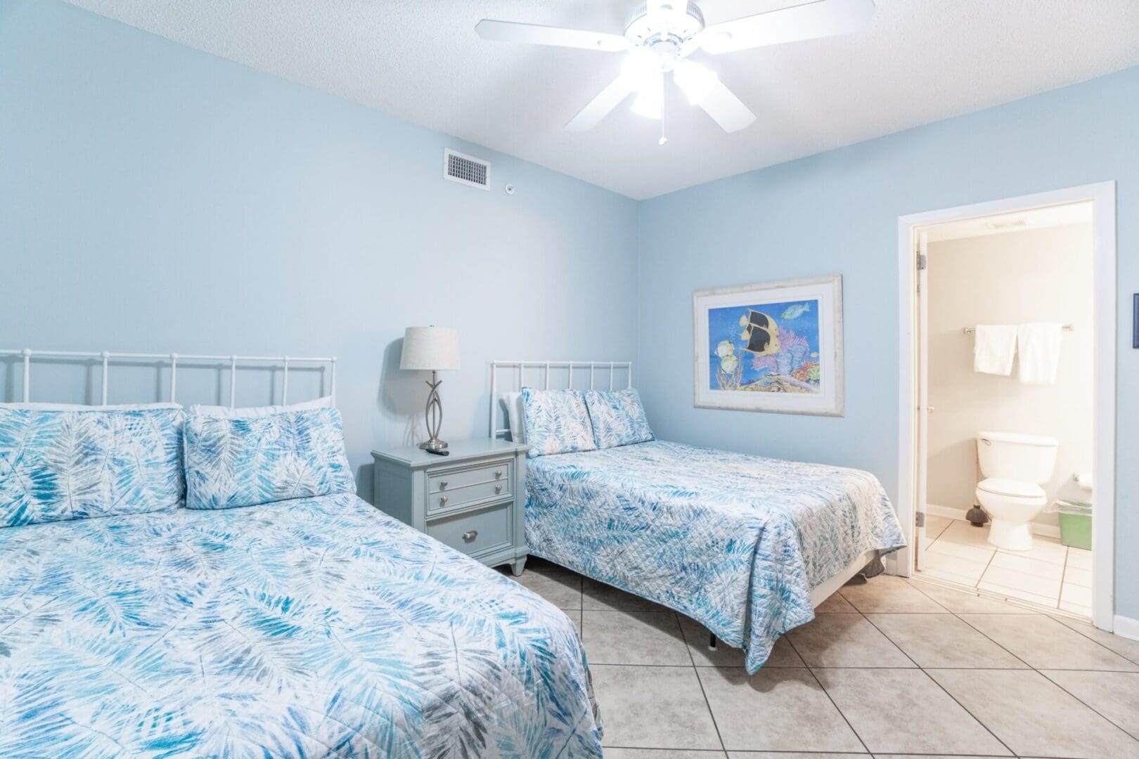 A bedroom with two beds and a dresser in it