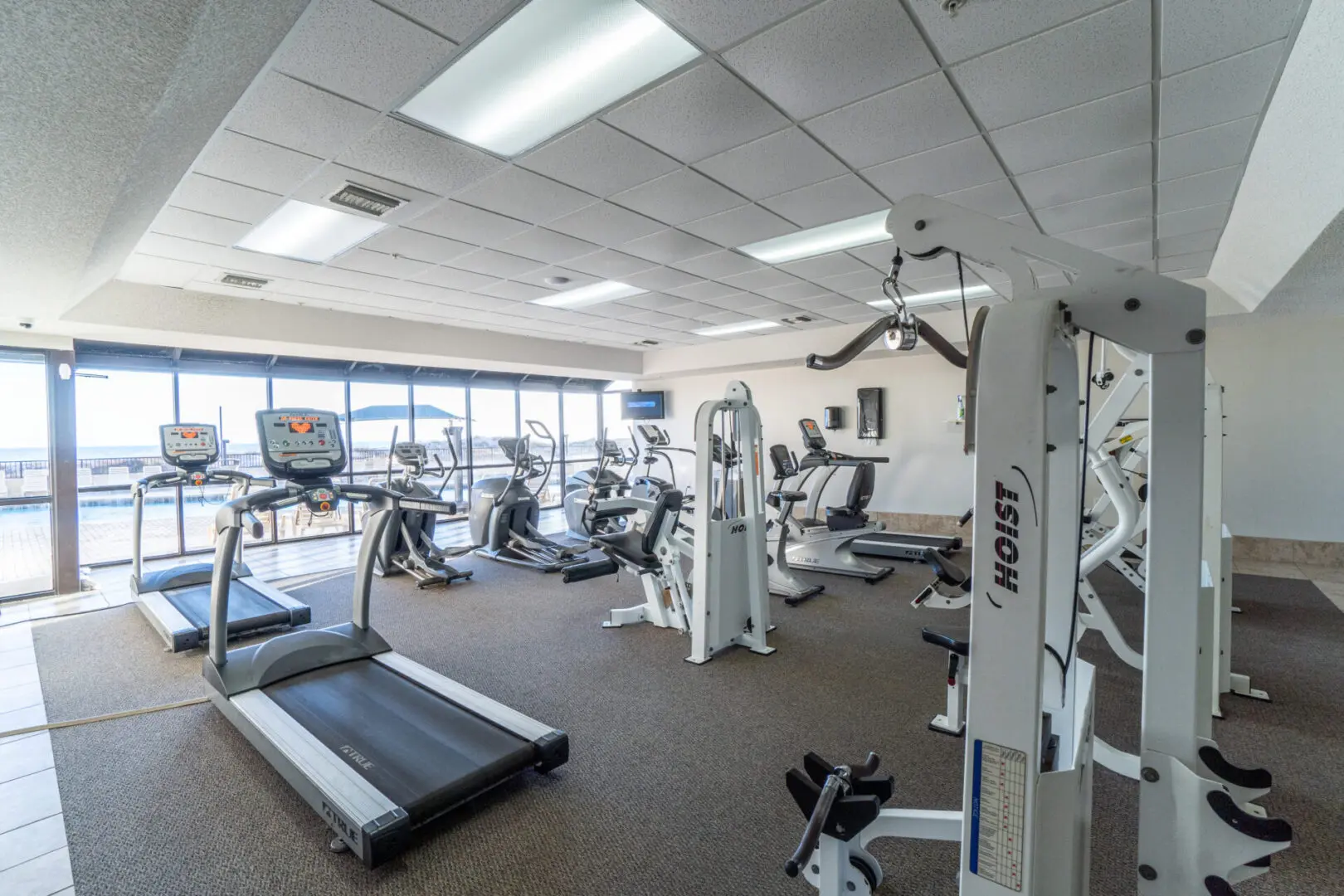 A gym with many machines and a window