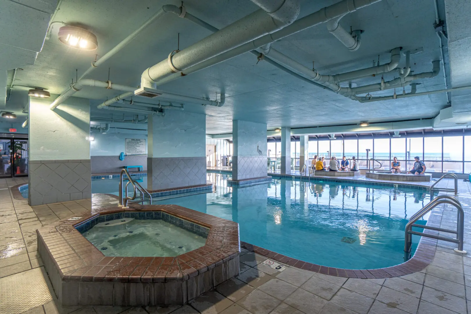 A large indoor pool with two hot tubs.