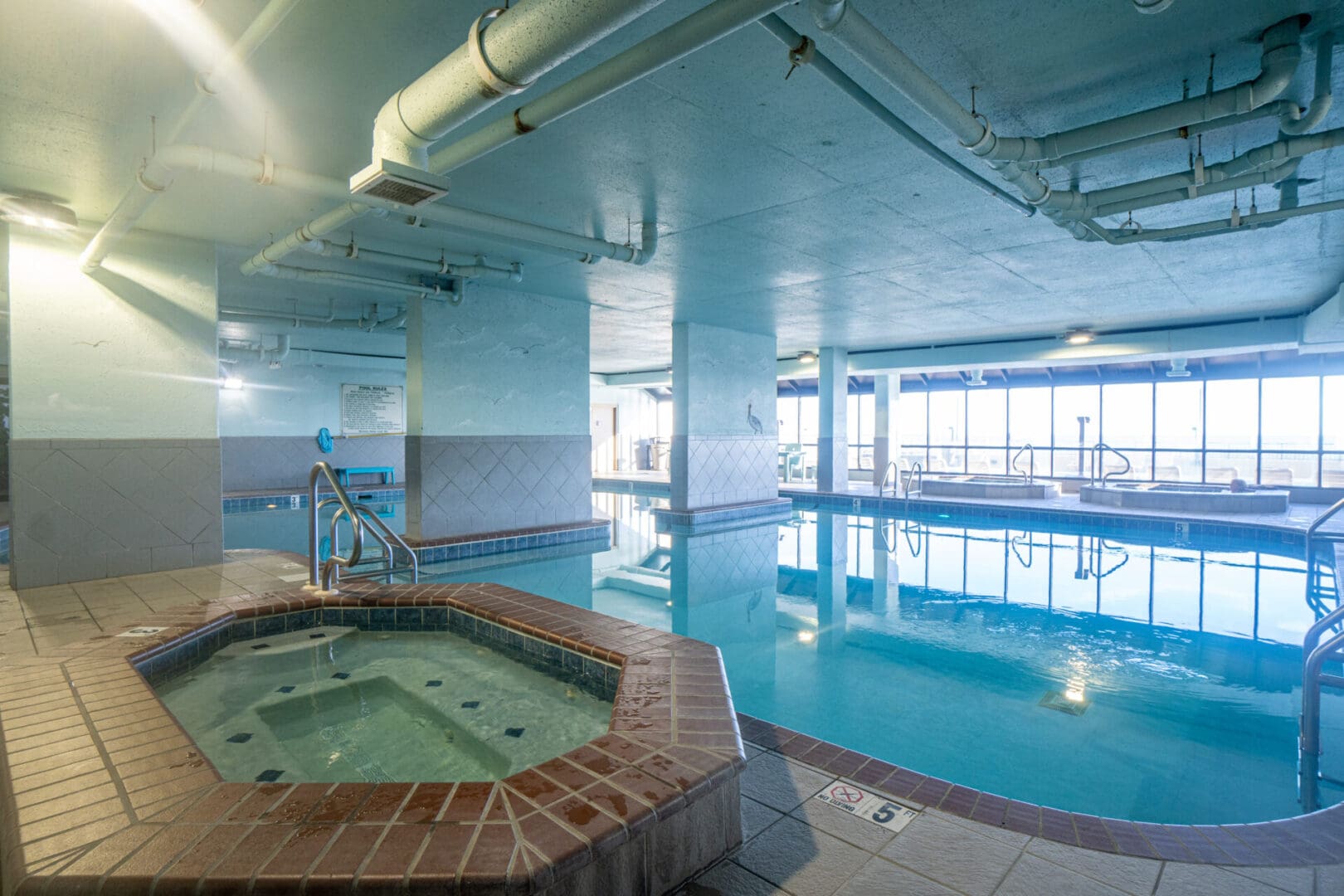 A large indoor pool with two hot tubs.