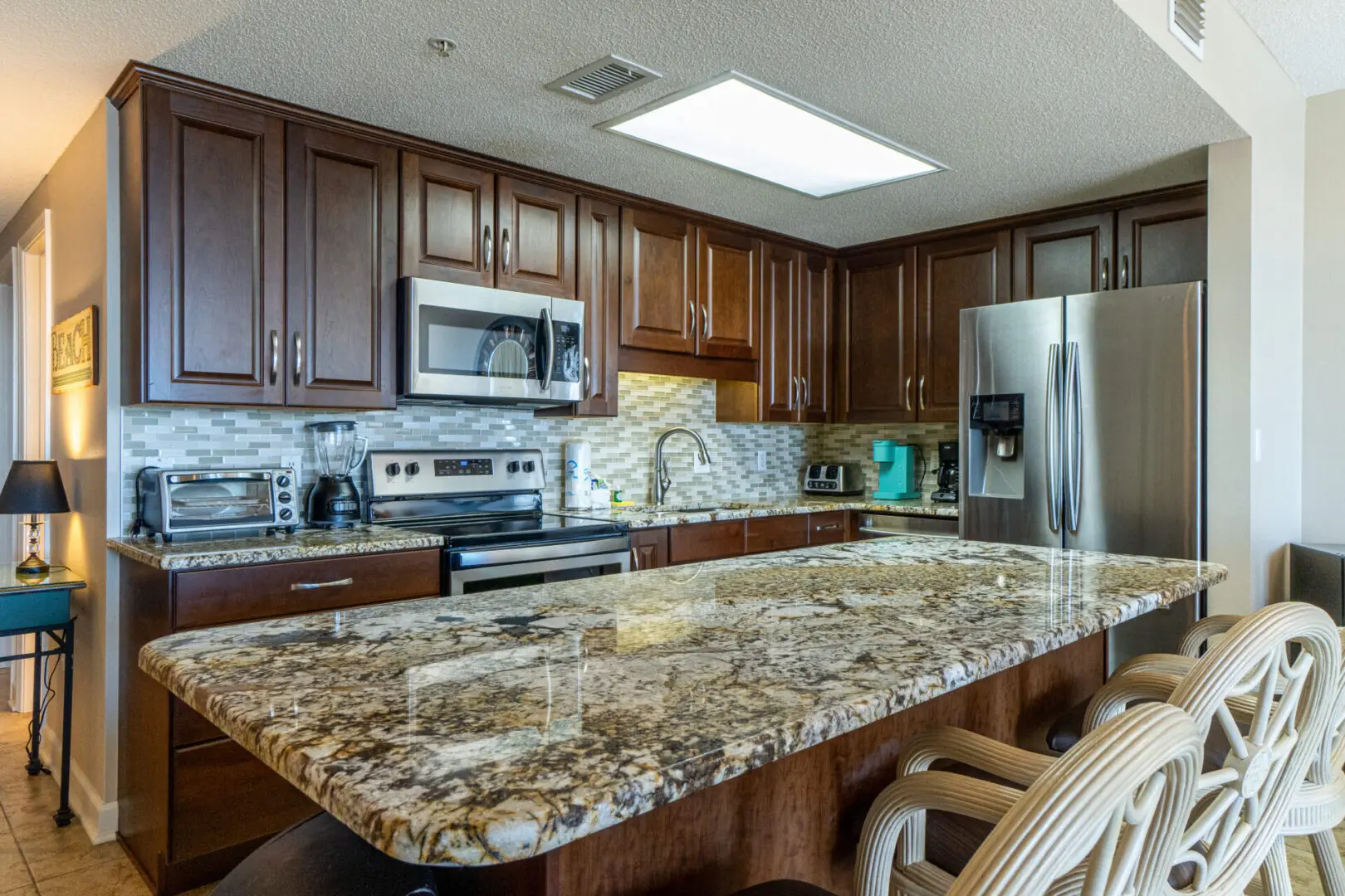 A kitchen with granite counter tops and wooden cabinets.