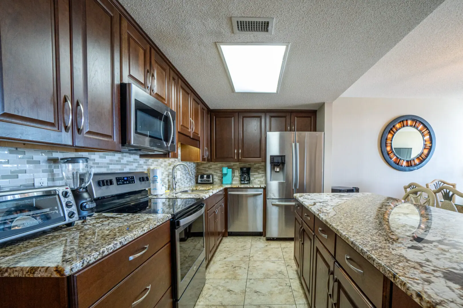 A kitchen with granite counter tops and stainless steel appliances.