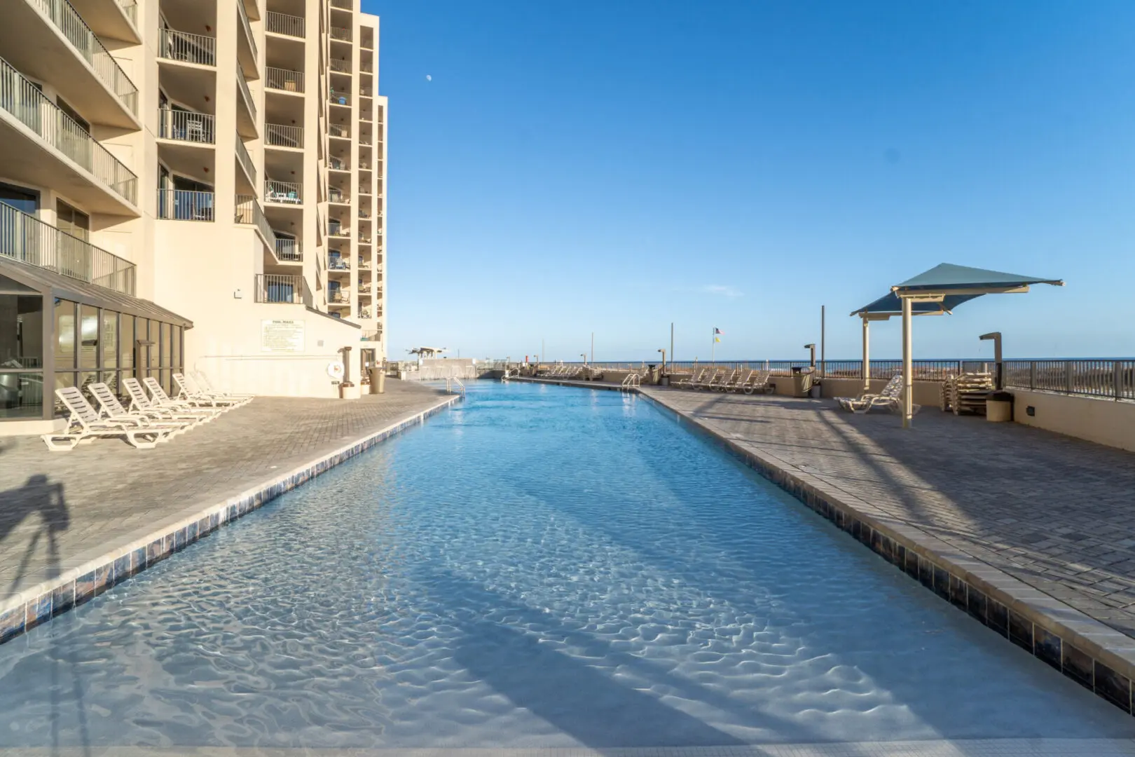 A pool with a view of the ocean and buildings.