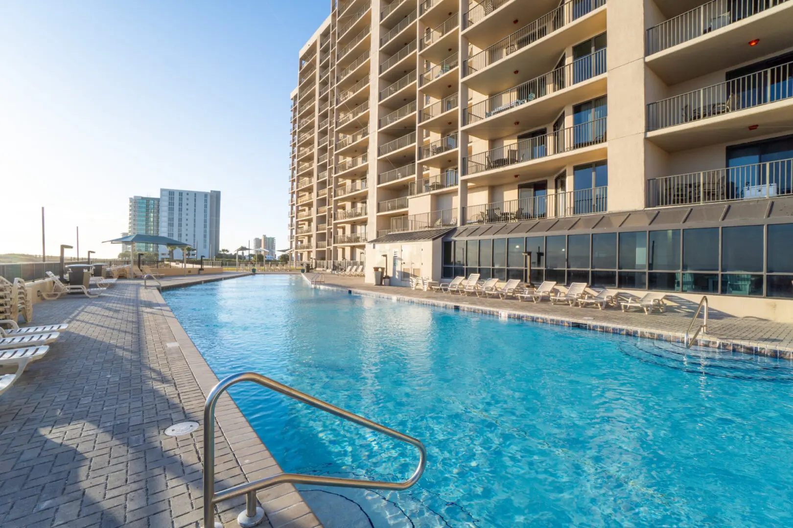 A pool with a view of the ocean and buildings.